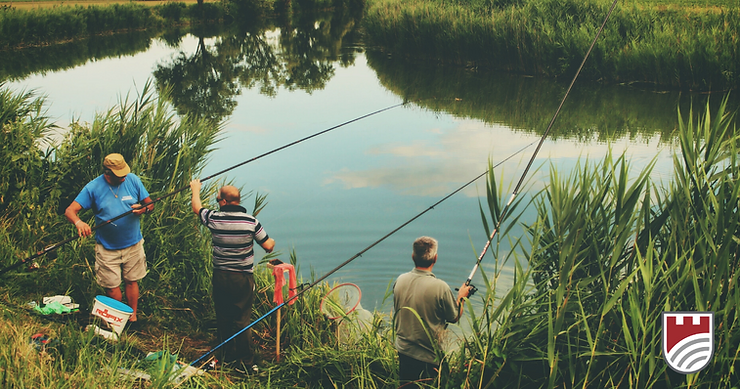 Three men are fishing by a river.